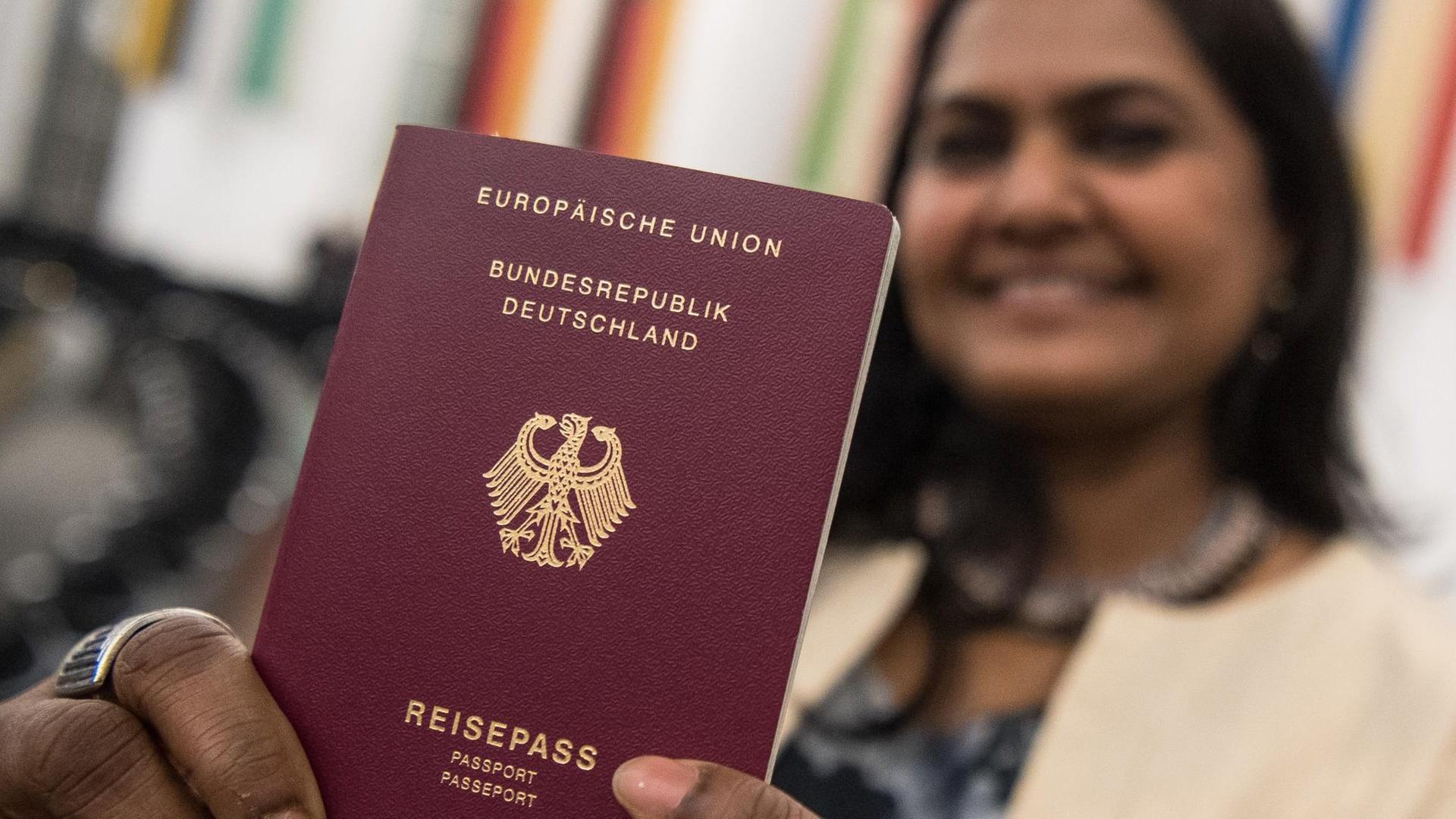 Eine Frau aus Indien hält am nach der Einbürgerungsfeier in der Paulskirche in Frankfurt am Main ihren deutschen Pass in die Kamera. Eine Frau aus Indien hält am nach der Einbürgerungsfeier in der Paulskirche in Frankfurt am Main ihren deutschen Pass in die Kamera.