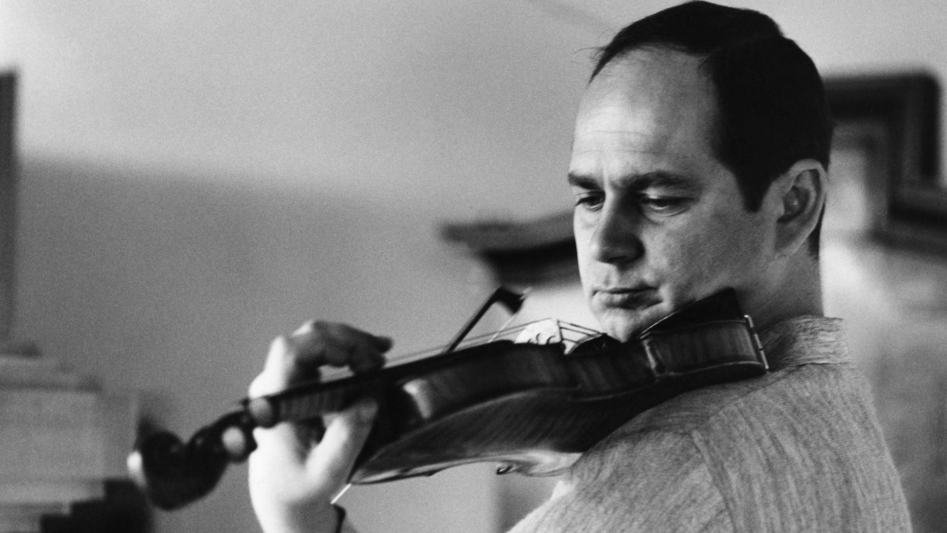 schwarz-weiss-Foto mit Saschko Gawriloff, er spielt Geige und trägt einen hellen, melierten Pullover, er schaut auf das Griffbrett