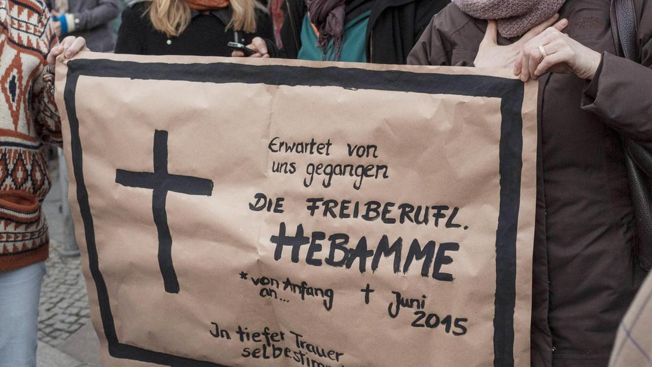 Eine Traueranzeige als Plakat bei einem Hebammenprotest in Berlin am 24.02.2014.