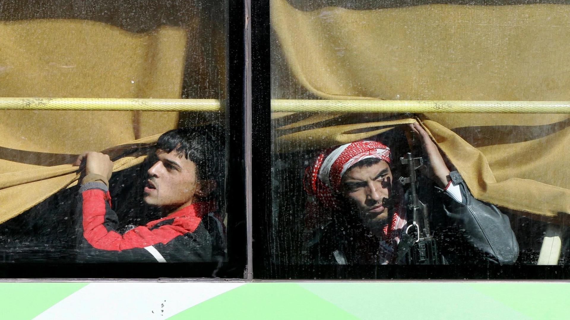 Kämpfer der syrischen Rebellen in einem Bus, der sie aus der Stadt Homs bringt.