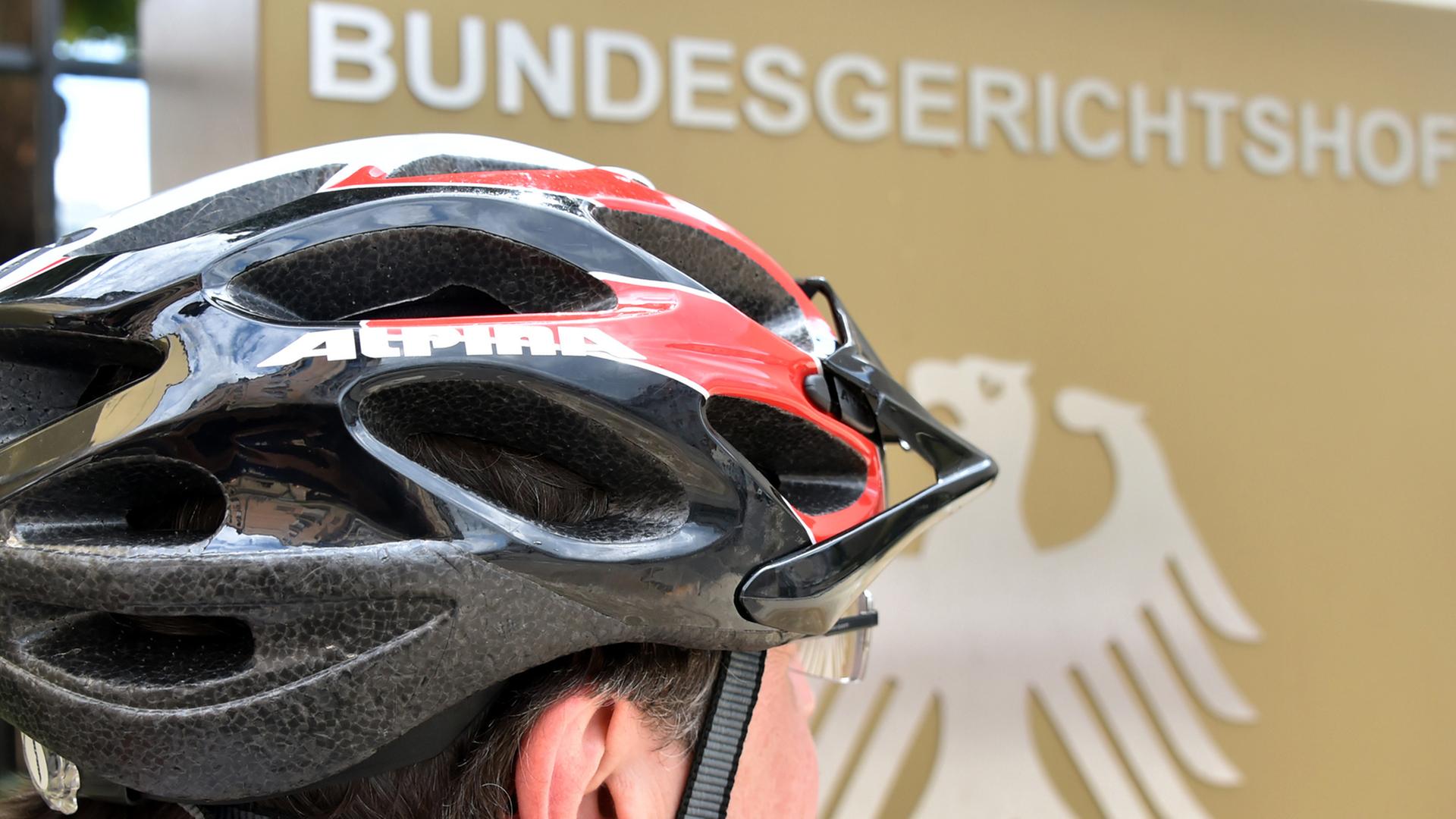 Ein Fahrradfahrer mit Helm steht am 16.06.2014 vor dem Bundesgerichtshof (BGH) in Karlsruhe (Baden-Württemberg).