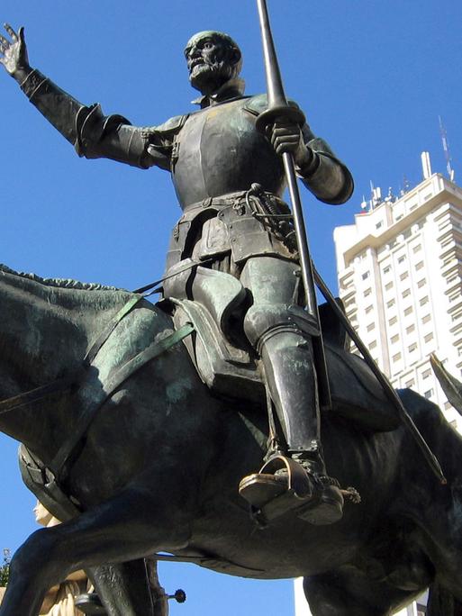 Skulpturen der Cervantes-Romanfiguren Don Quijote und Sancho Panza vor dem Torre de Madrid (Hintergrund) an der Plaza Espana in Madrid.