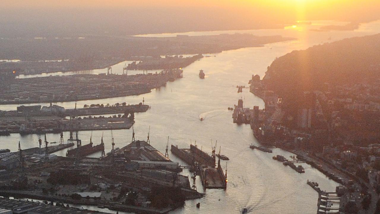 Teile des Hamburger Hafens und die Elbe im Licht der untergehenden Sonne.