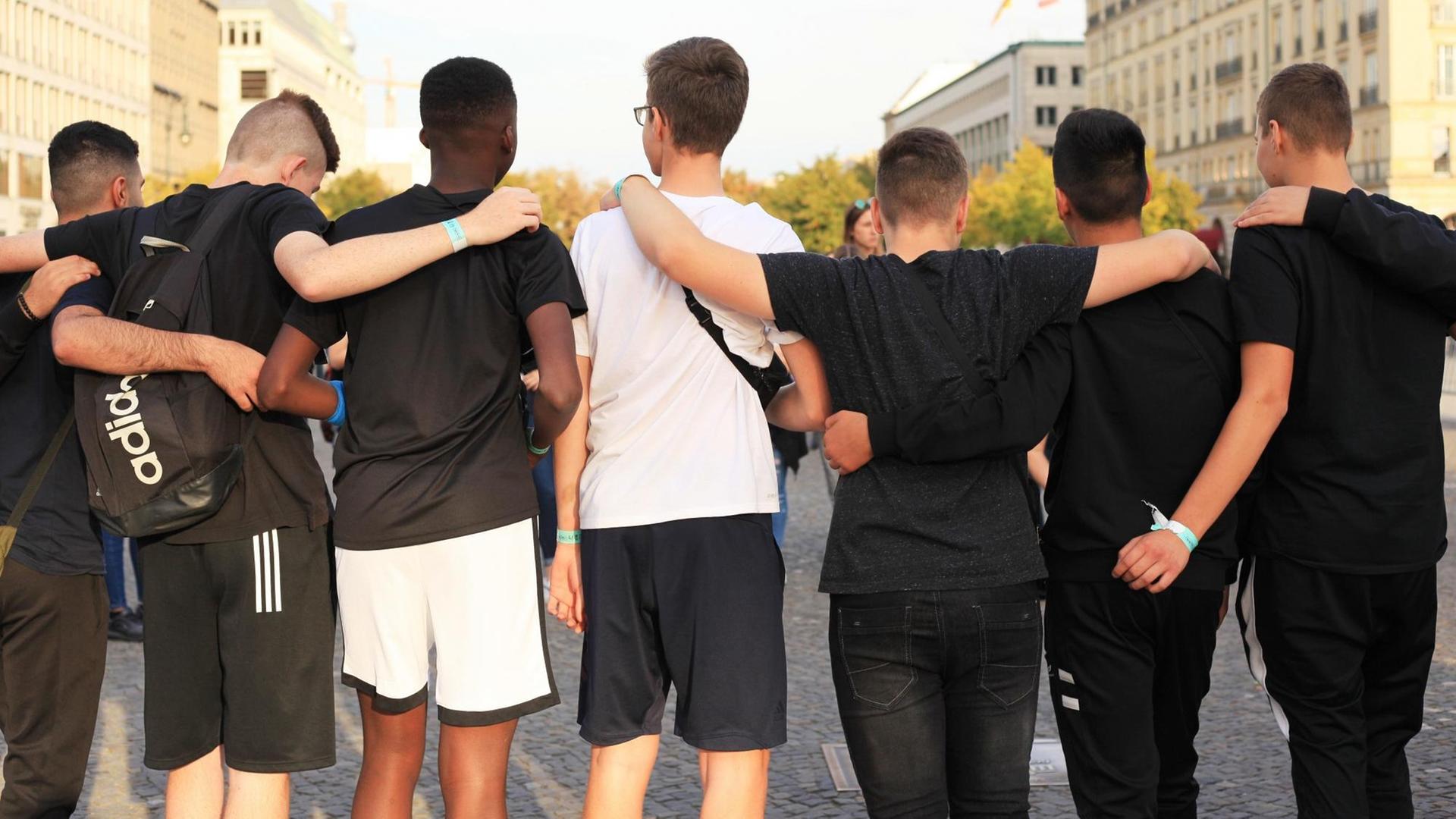 Jugendliche posieren in Berlin für ein Foto, manche davon mit Migrationshintergrund.