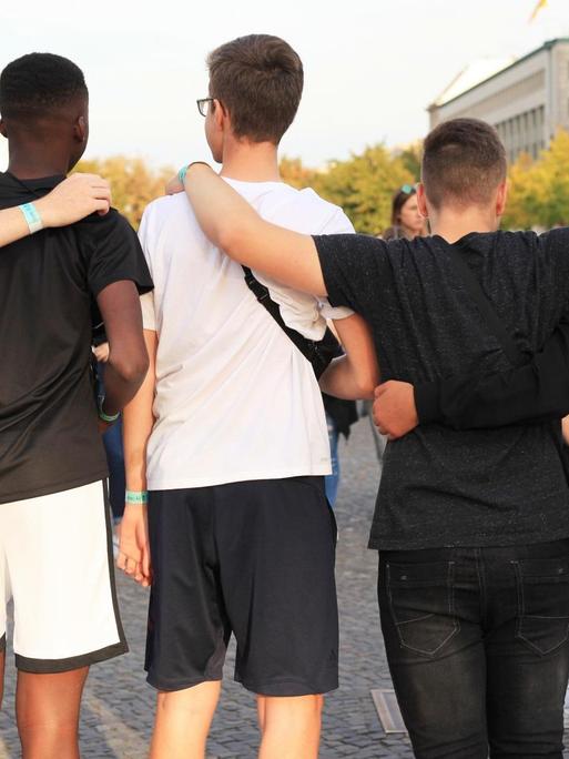 Jugendliche posieren in Berlin für ein Foto, manche davon mit Migrationshintergrund.