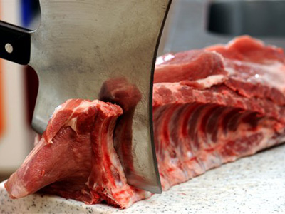 Schweinekotellets werden beim Fleischer zubereitet