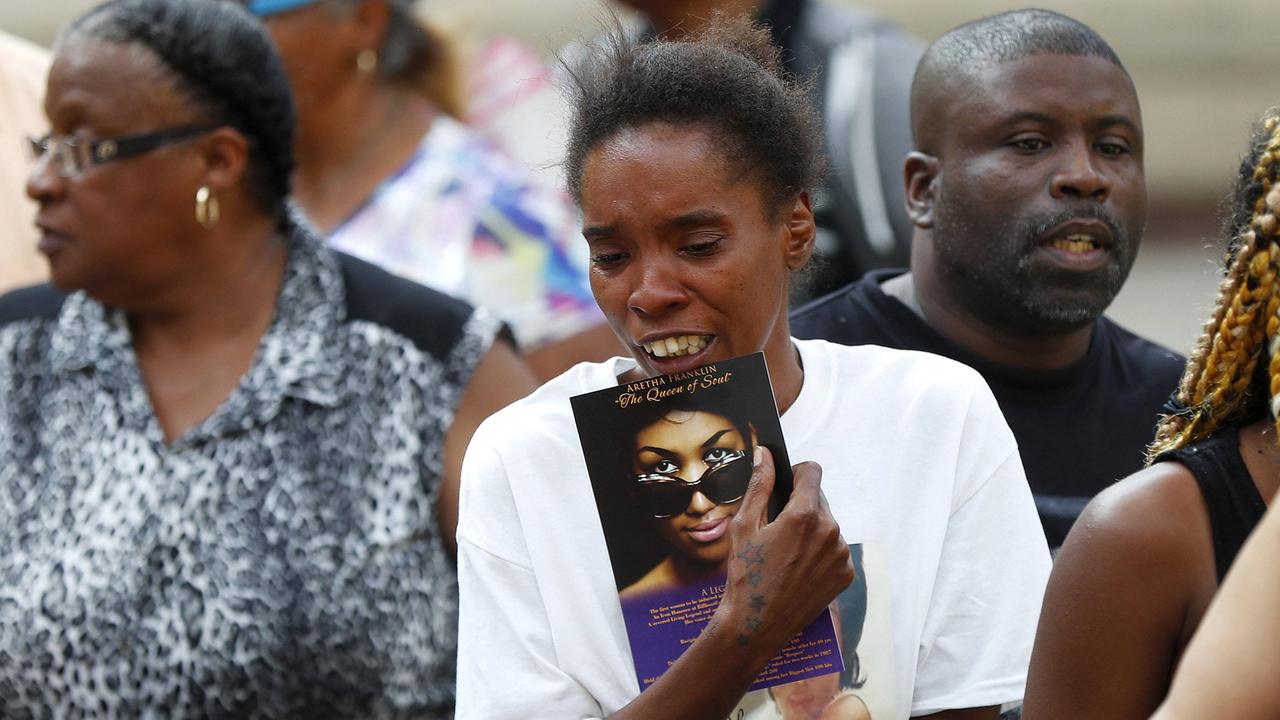 Eine Frau bricht vor dem Sarg von Aretha Franklin in Tränen aus, in ihren Händen hält sie ein Bild der Sängerin.