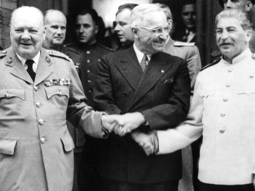 Der britische Premierminister Winston Churchill, der amerikanische Präsident Harry S. Truman und der sowjetische Diktator Josef Stalin (v.l.) reichen sich während der Potsdamer Konferenz im Juli 1945 die Hände.