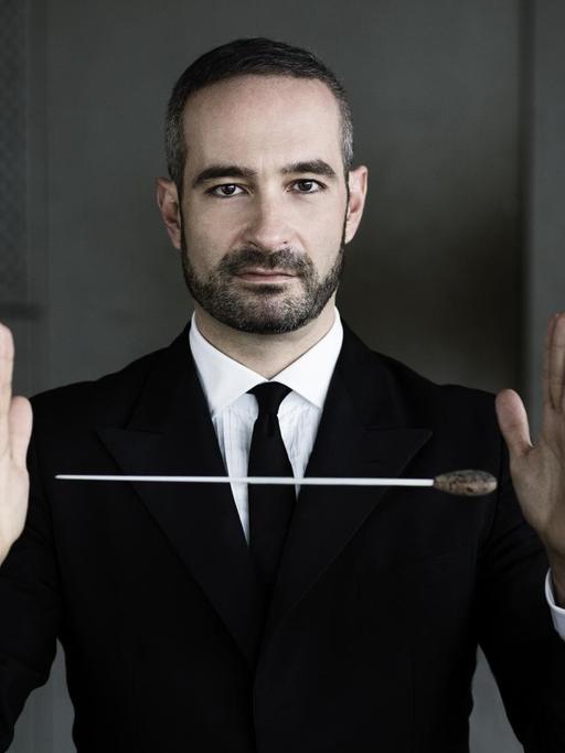 Der Dirigent Antonello Manacorda, ein Dirigierstab scheint zwischen seinen Händen zu schweben