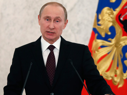Russlands Präsident Wladimir Putin steht bei seiner Rede an die Nation an Mikrofonen, im Hintergrund eine Flagge mit dem russischen Wappen.