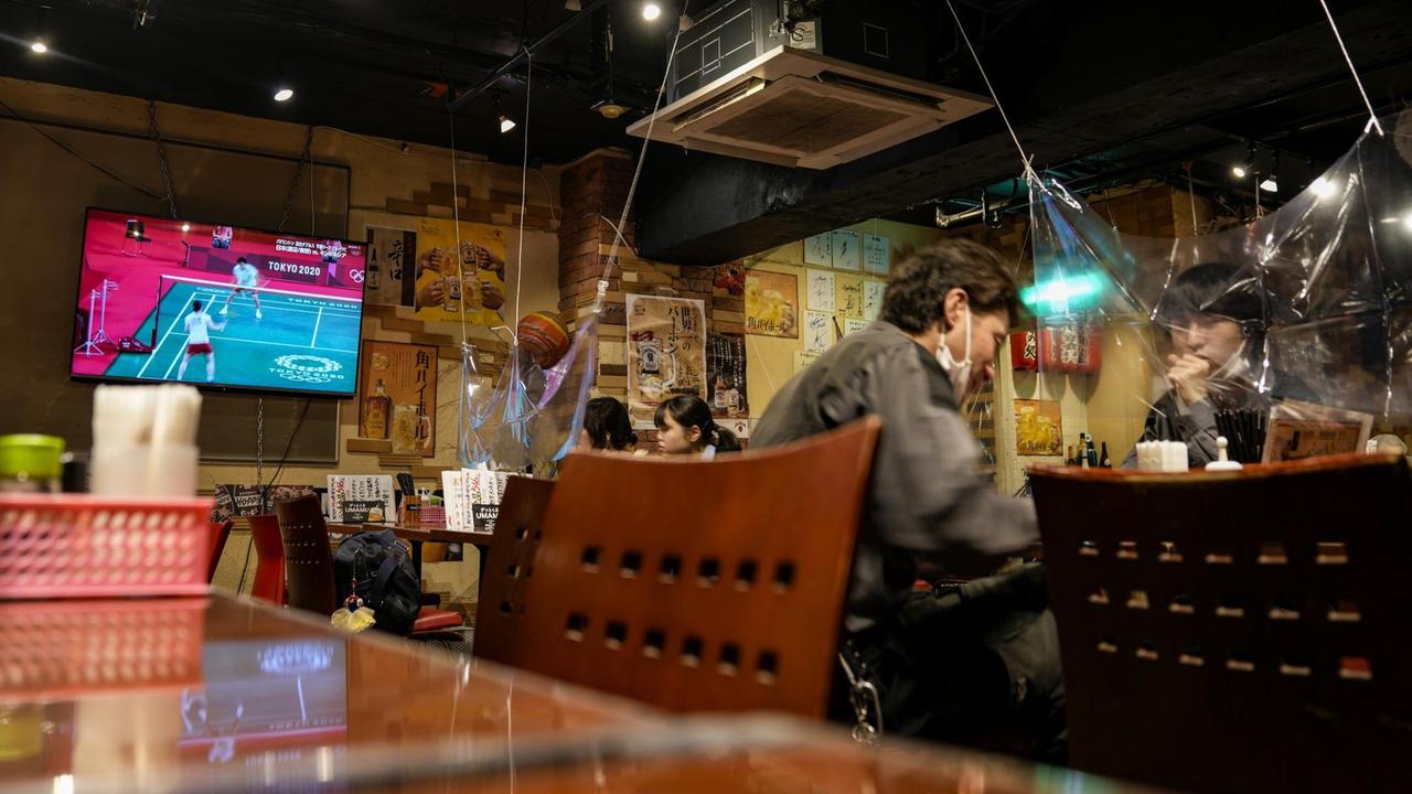 Die Olympia-Übertragungen laufen in einem Restaurant in Japan kaum beachtet im Hintergrund. 
