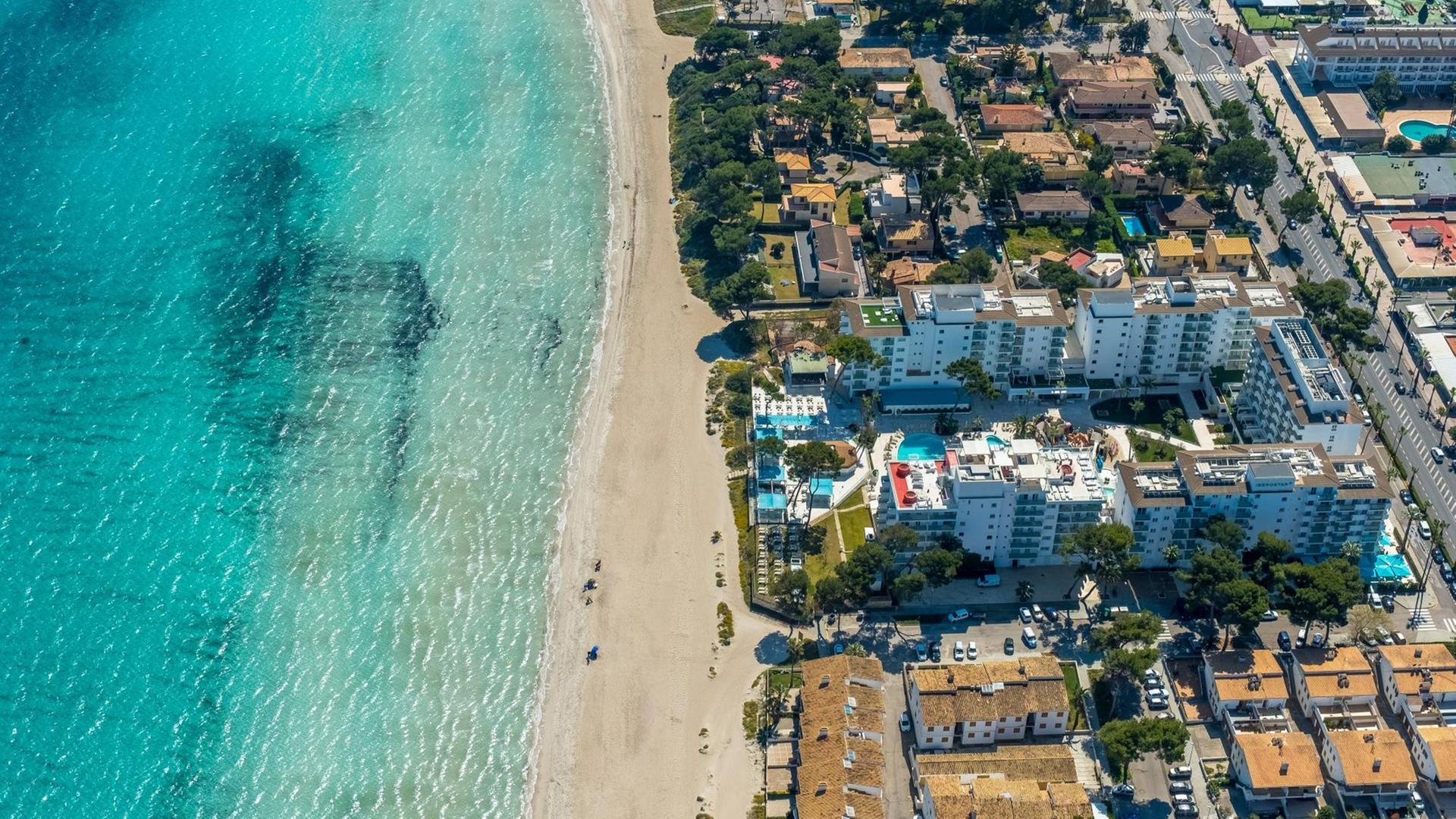 Luftaufnahme vom Strand von Alcúdia mit angrenzenden Hotelanlagen.