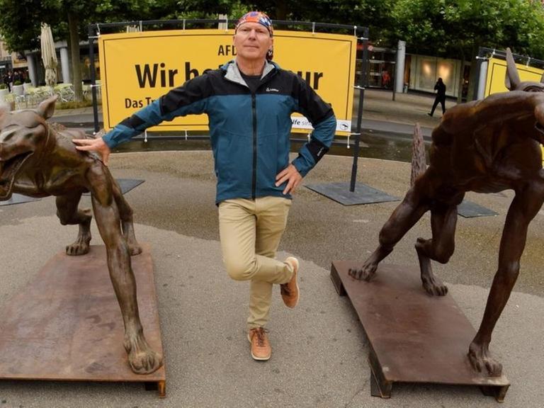 Der Brandenburger Künstler Rainer Opolka steht zwischen seinen Wolfsfiguren auf dem Königsplatz in Kassel.