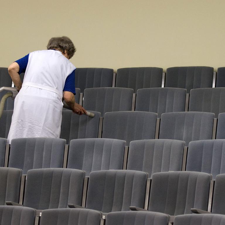 Eine Mitarbeiterin des Theaters in Meißen (Sachsen) reinigt mit einem Staubsauger die Sitze im Zuschauersaal des Theaters. 