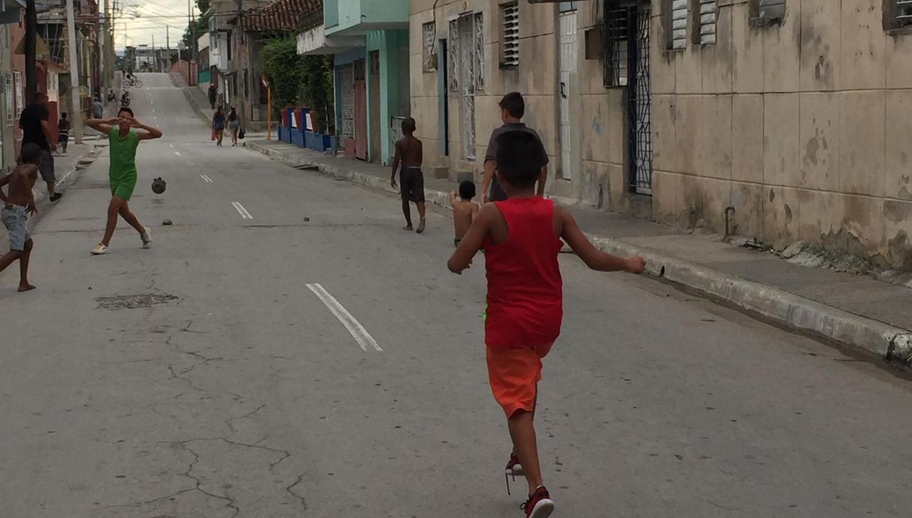 Kinder spielen Fußball in einer Straße in Kubas Hauptstadt Havanna.