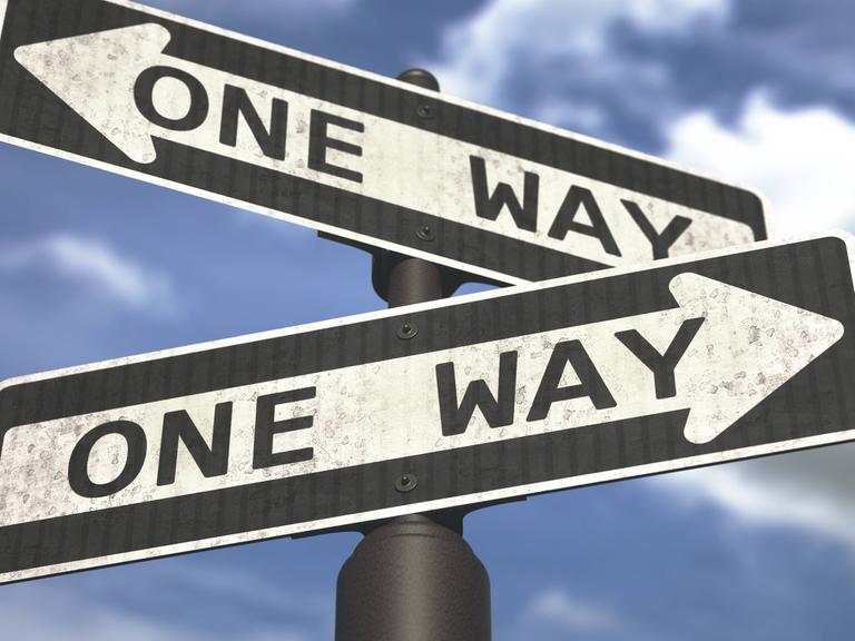 Zwei Schilder mit der Aufschrift "One Way" zeigen in entgegengesetzte Richtungen