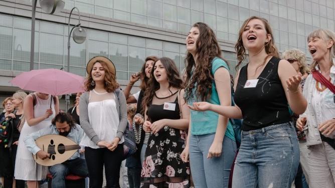 Junge Leute ziehen singend durch eine Berliner Straße
