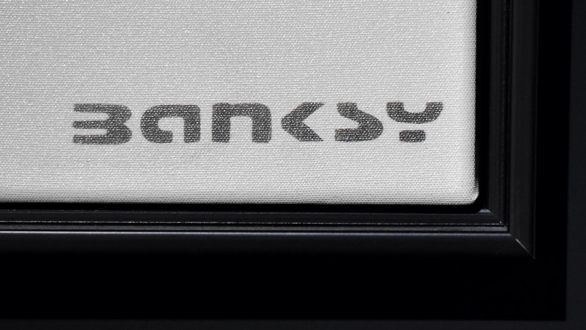 Der Schriftzug Banksy in der rechten unteren Ecke eines Bildes. Der Schriftzug Banksy in der rechten unteren Ecke eines Bildes.