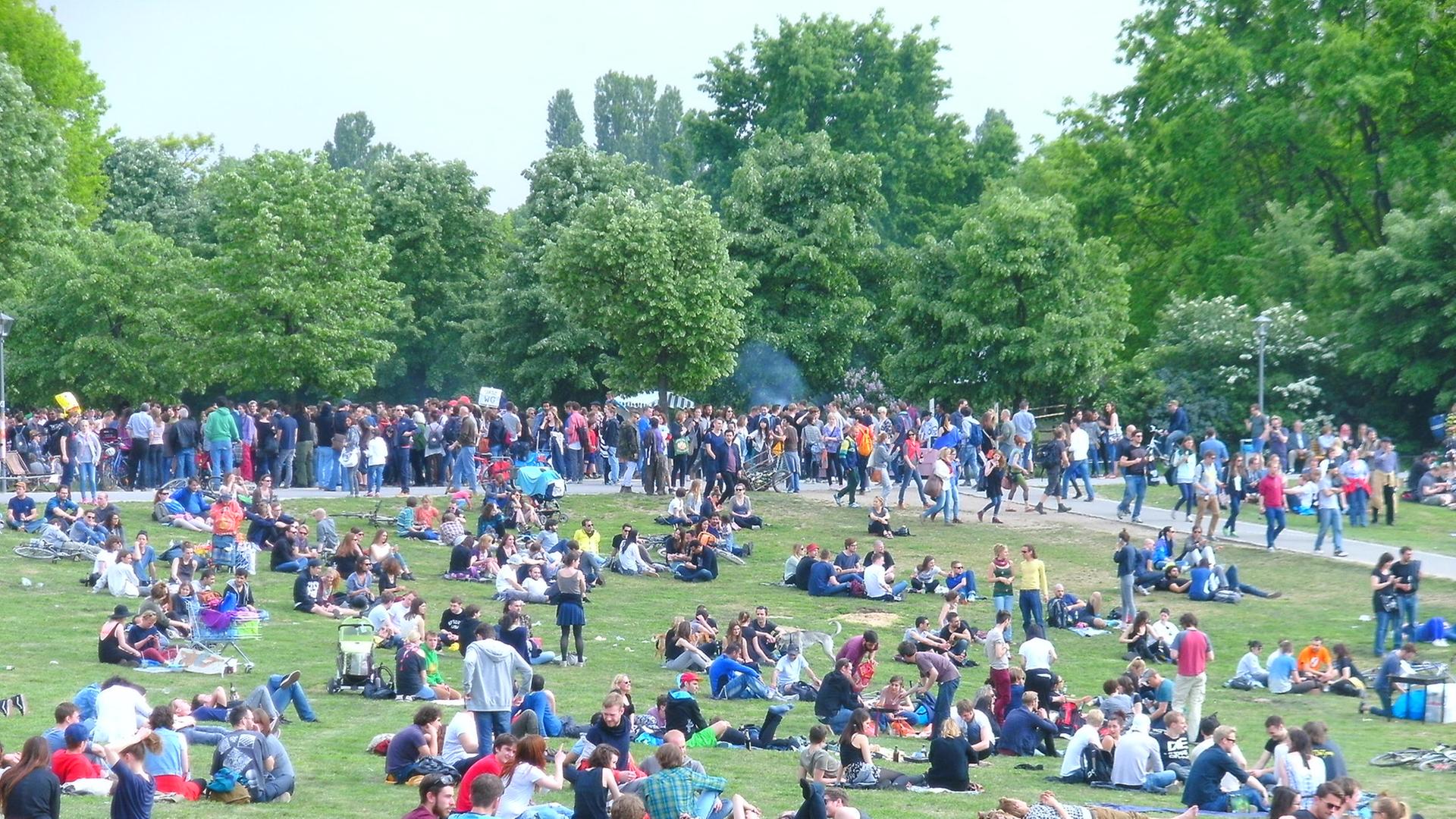 Menschen sitzen auf der Grünfläche vom Görlitzer Park.