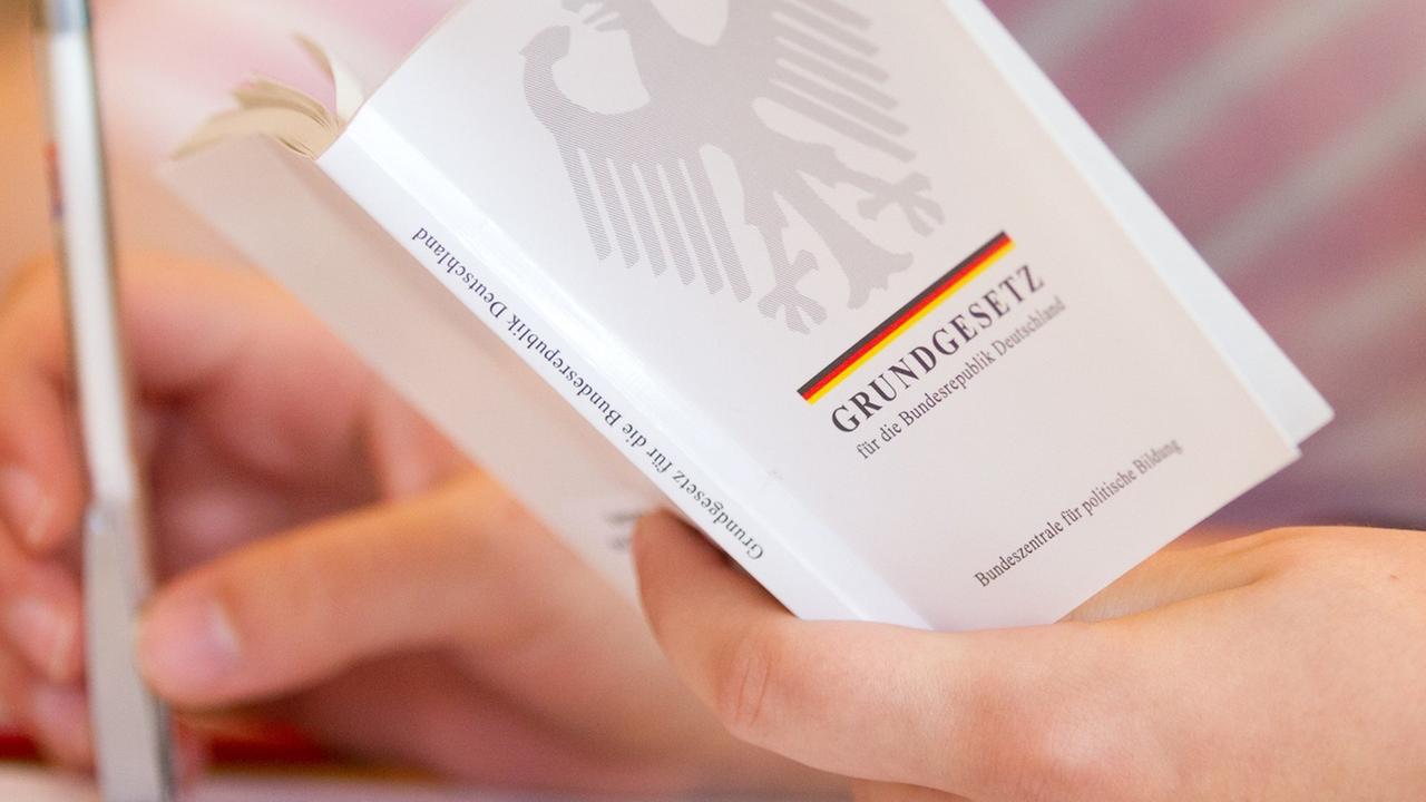 Eine Jura-Studentin hält in einer Vorlesung an der Universität Osnabrück (Niedersachsen) eine Ausgabe vom Grundgesetz in der Hand.
