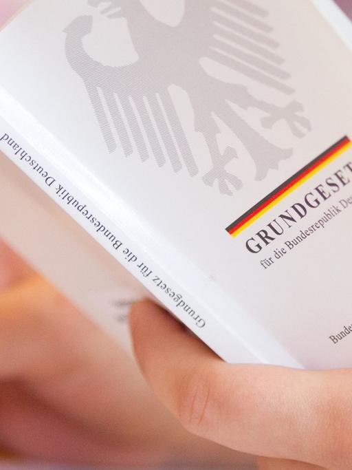 Eine Jura-Studentin hält in einer Vorlesung an der Universität Osnabrück (Niedersachsen) eine Ausgabe vom Grundgesetz in der Hand.