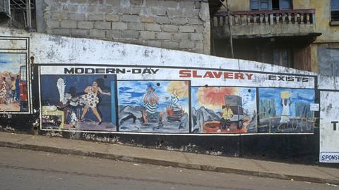 Das Foto aus Freetown, der Hauptstadt von Sierra Leone zeigt eine Mauer mit Straßenmalerei und der Überschrift "modern slavery exist."