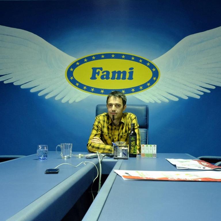 Mladen Falamić im blauen Konferenzraum, hinter sich das geflügelte Logo seins Familienbetriebs