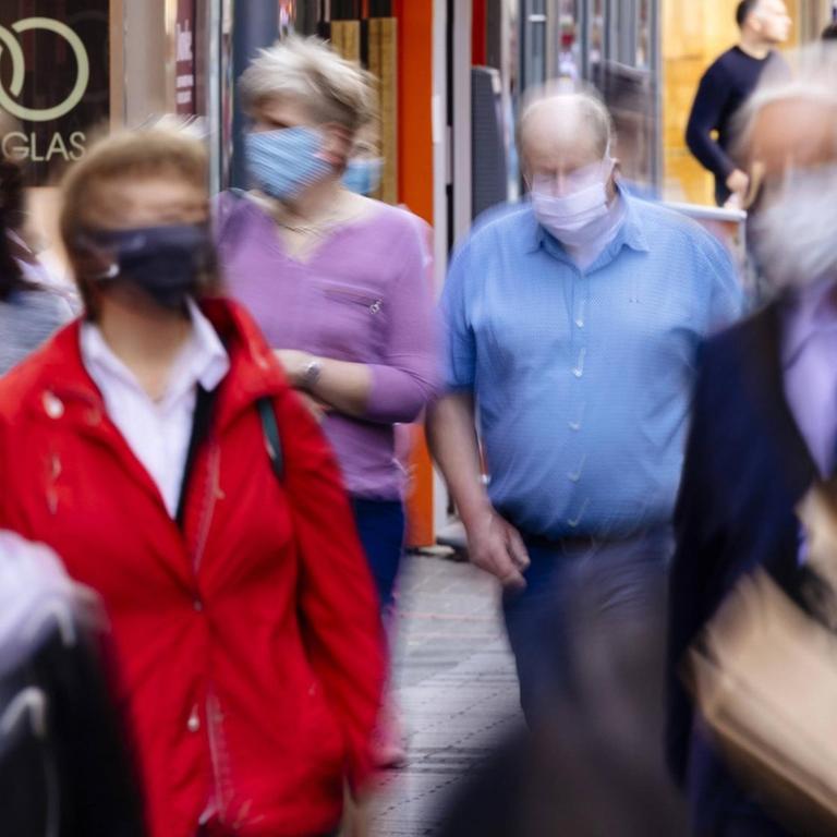 Menschen mit Mund-Nase-Masken in der Fußgängerzone in Köln