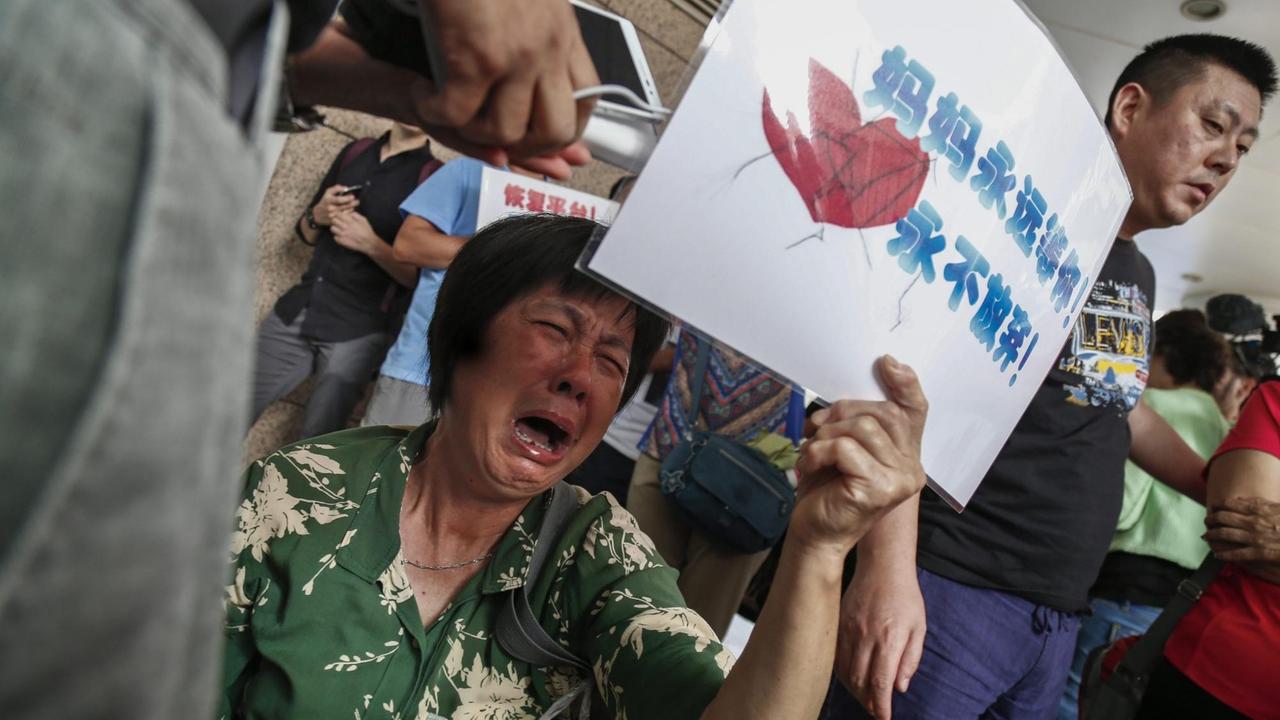 Angehörige der Passagiere des verschollenen Fluges MH-370 demonstrieren vor dem Büro von Malaysia Airlines.
