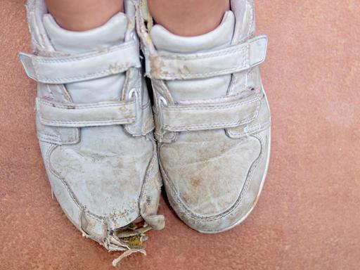 Füsse in ramponierten Sportschuhen