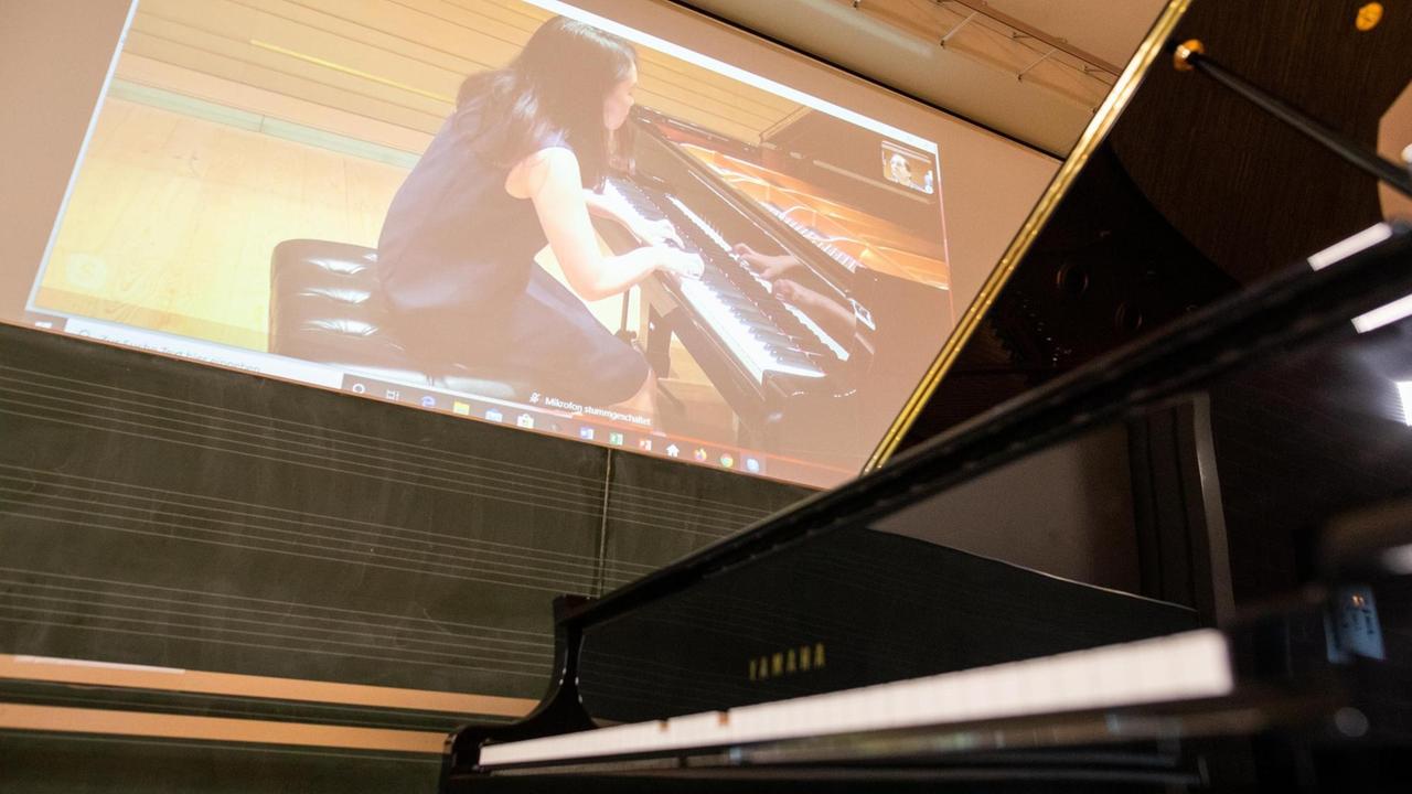 Momoko Watabe ist via Skype zugeschaltet und spielt über eine zweite Internetverbindung in Tokio sitzend das Klavier in einem Prüfungsraum der Hochschule für Musik Freiburg, weil internationale Bewerber nicht reisen durften.