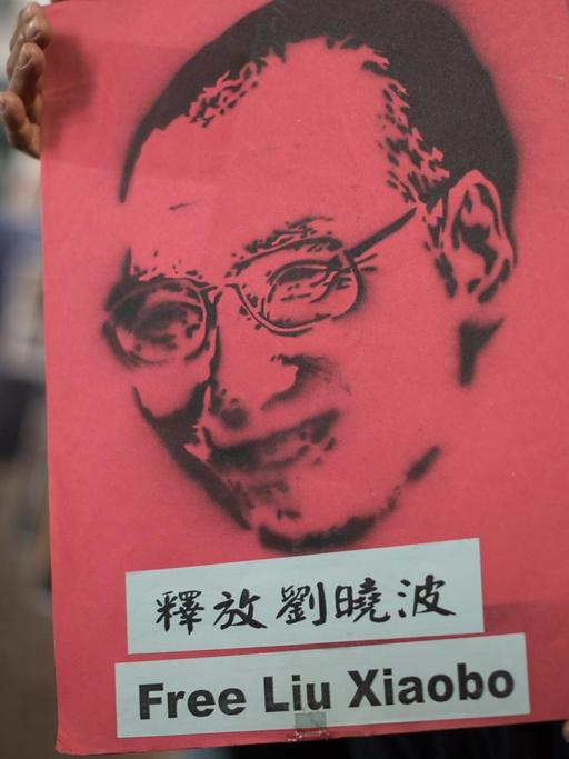 Demonstranten tragen ein Plakat mit dem Bild und den Worten "Free Liu Xiaobo"