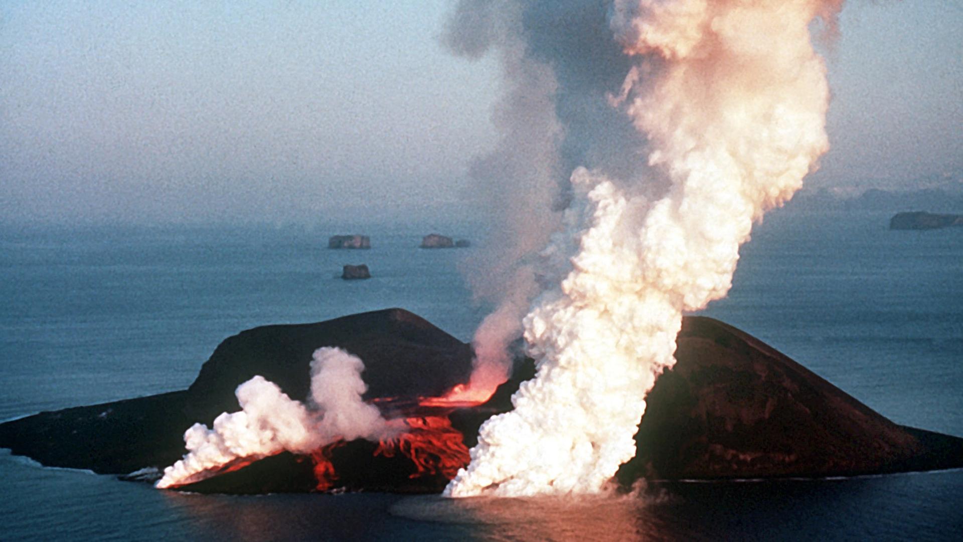 Dampfwolken steigen von der Vulkaninsel Surtsey in die Luft. Die Insel entstand 1963 durch einen Vulkanausbruch unter Wasser und liegt rund 20 Kilometer entfernt von Heimaey, der Hauptinsel der isländischen Westmännerinseln | picture alliance / dpa / Polfoto