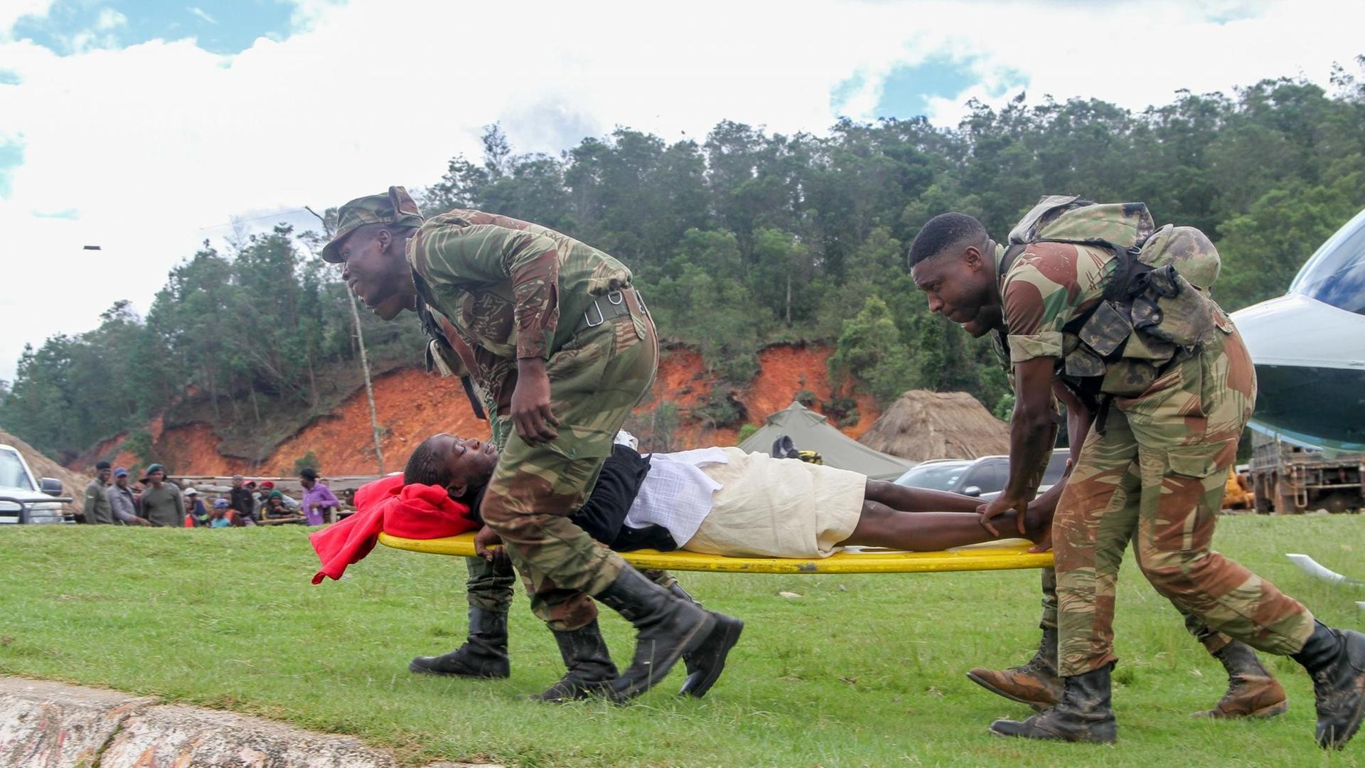 Ein Schwerverletzter wird von Hilfskräften zu einem Hubschrauber gefahren in Chimanimani in Simbabwe am 19. März 2019.