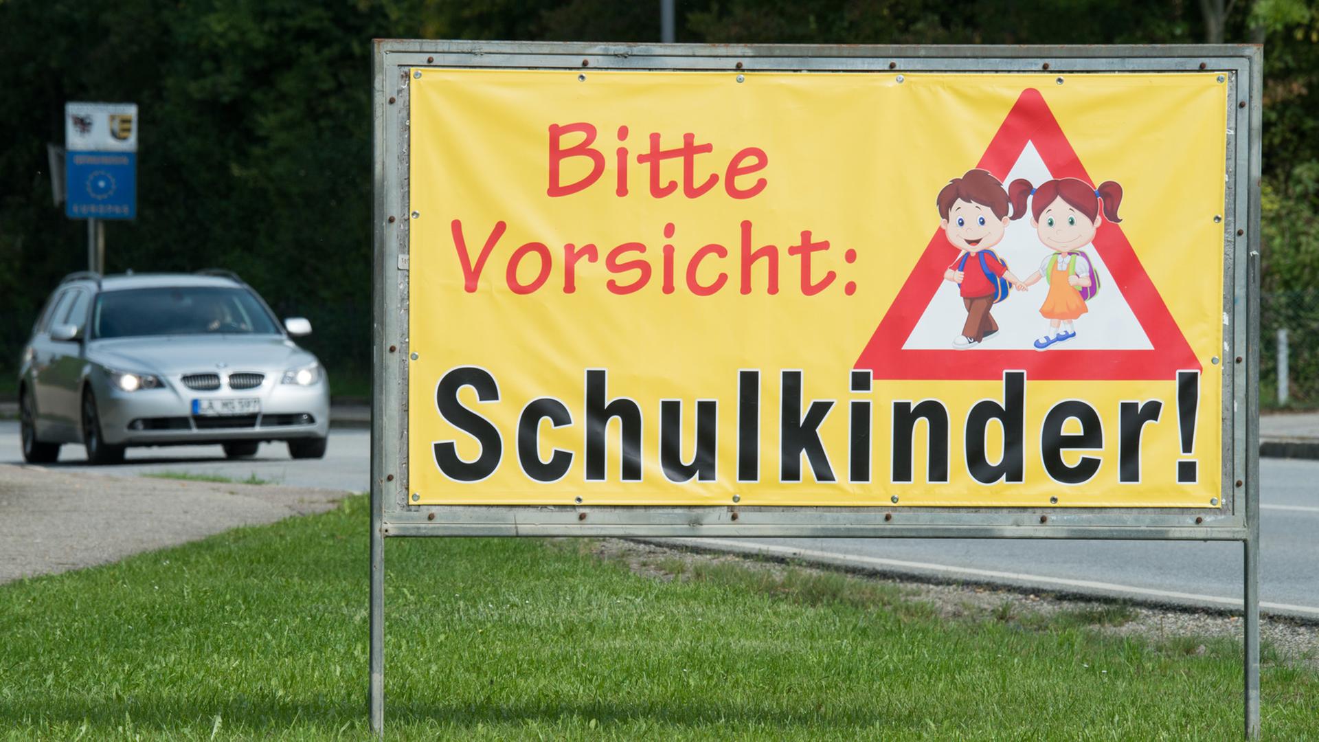 Ein Transparent mit der Aufschrift "Bitte Vorsicht: Schulkinder!" steht am Ortsrand von Neufahrn (Bayern).