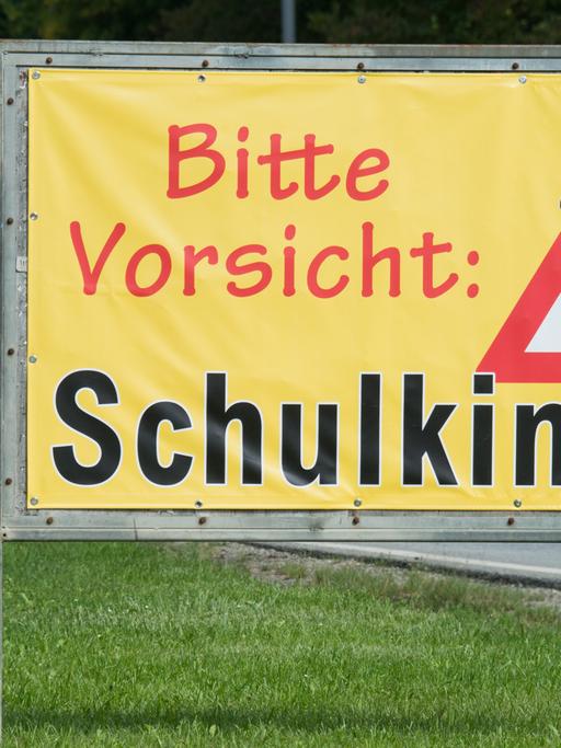 Ein Transparent mit der Aufschrift "Bitte Vorsicht: Schulkinder!" steht am Ortsrand von Neufahrn (Bayern).