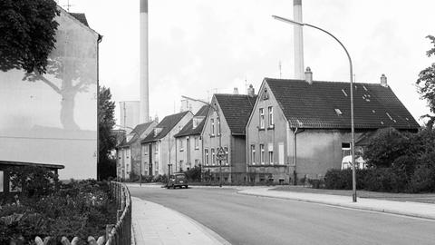 Häuser einer Arbeitersiedlung in Gelsenkirchen in Nordrhein-Westfalen, im Hintergrund Schornsteine einer Fabrik