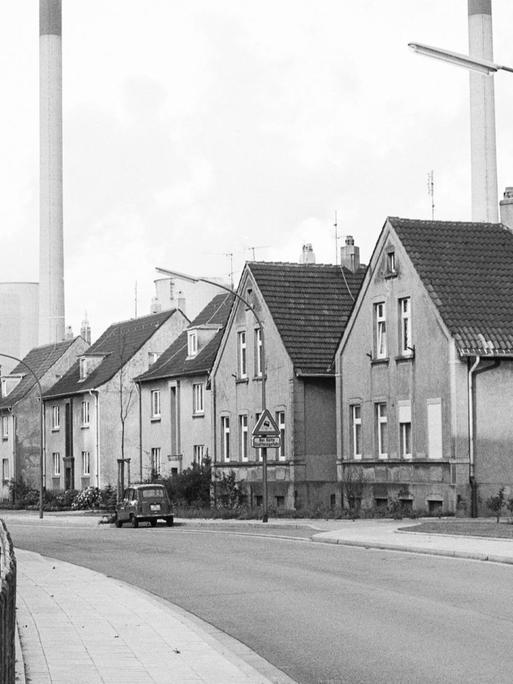 Häuser einer Arbeitersiedlung in Gelsenkirchen in Nordrhein-Westfalen, im Hintergrund Schornsteine einer Fabrik
