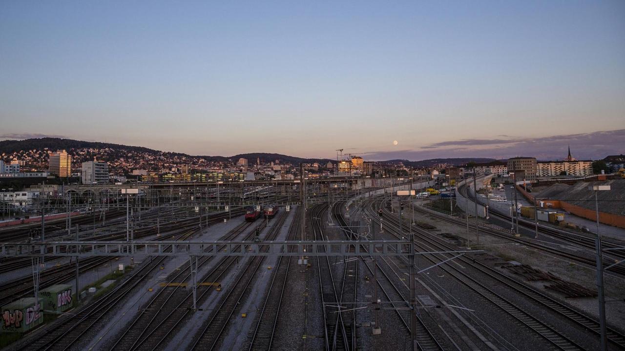 Panoramablick in Abendstimmung über das komplexe Schienennetzwerk außerhalb des Zücher Hauptb