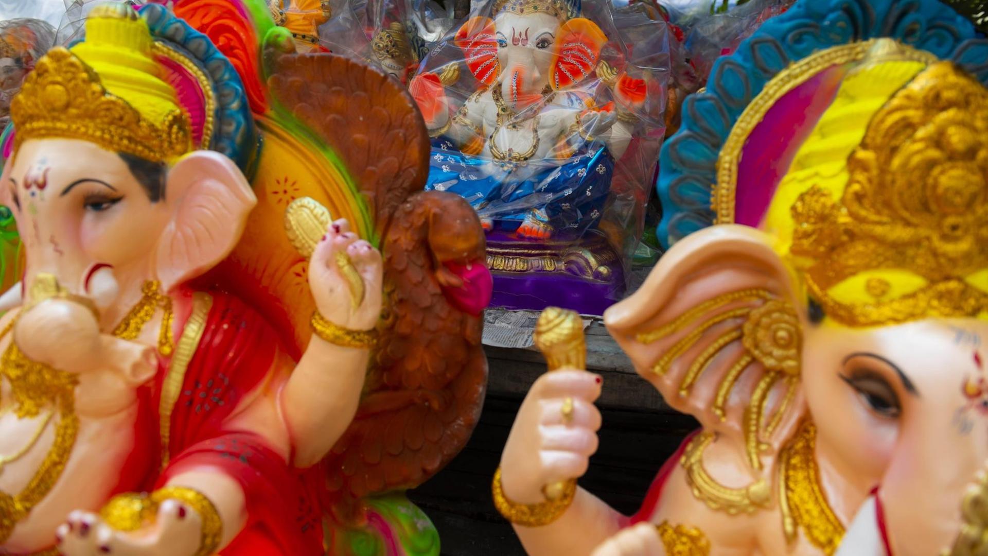 Bunte Symbolfiguren des Gottes Ganesha. Sie gelten in Indien auch als Glücksbringer.
