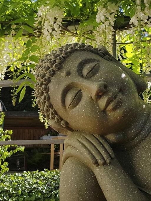 Buddhastatue auf einer Terrasse.