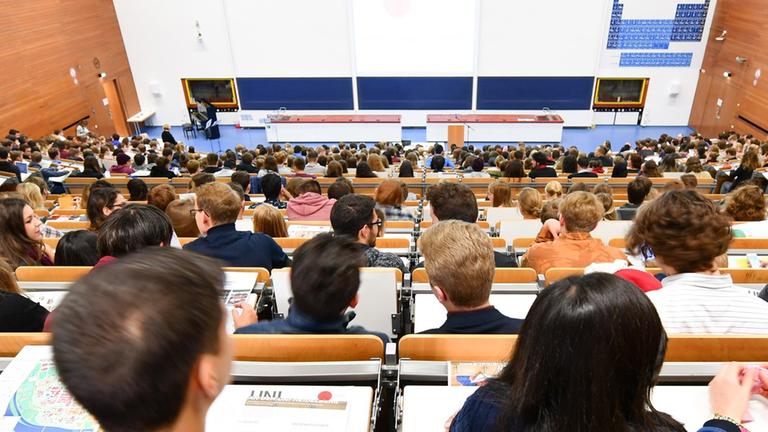 Studenten sitzen in Heidelberg an der Universität bei der Begrüßung der Erstsemster-Studenten in einem Hörsaal.