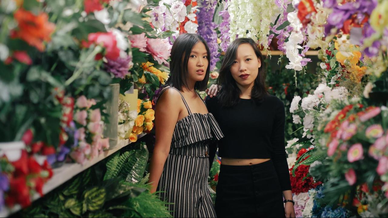 Die Macherinnen des Podcast Rice and Shine Minh Thu Tran und Vanessa Vu zwischen bunten Blumen in einem Asia-Markt.