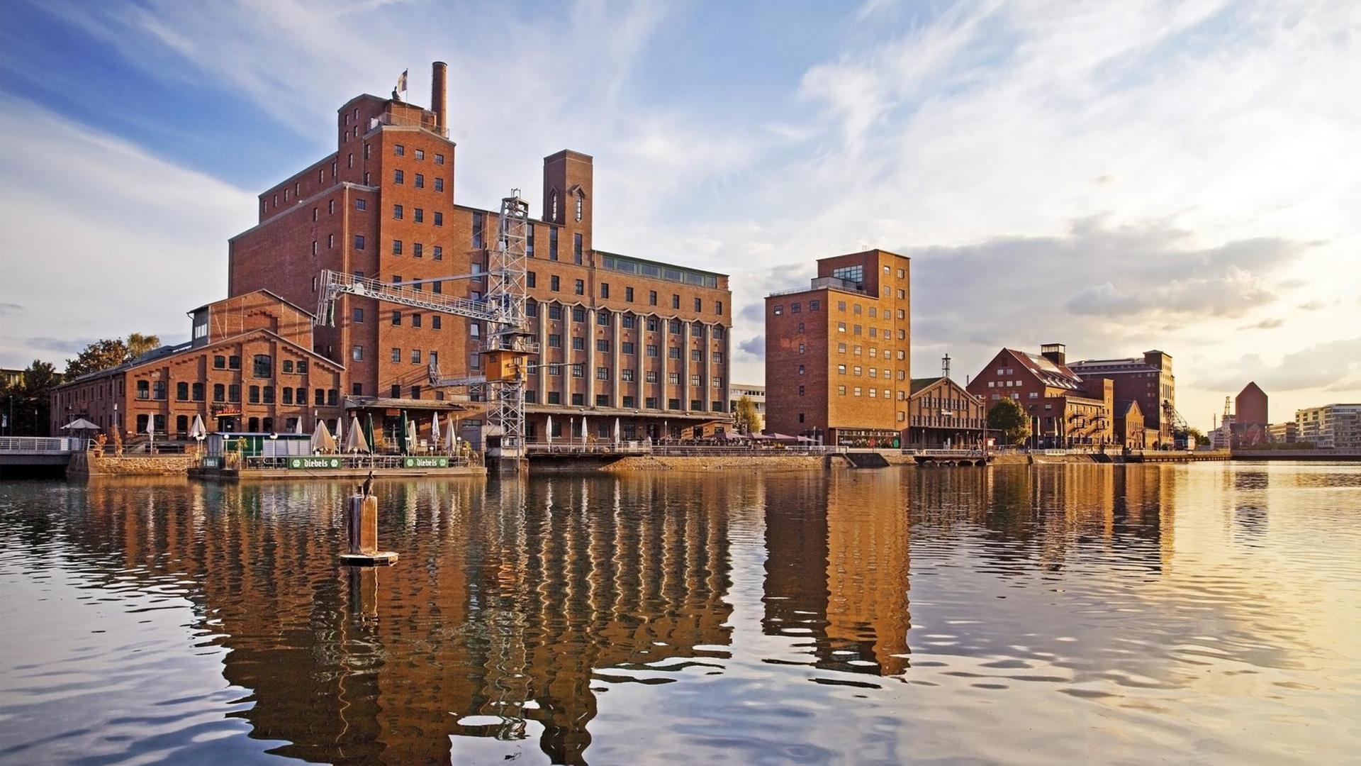 Die Werhahn-Mühle in Duisburg. Eine großes Backsteingebäude in einem Hafen.