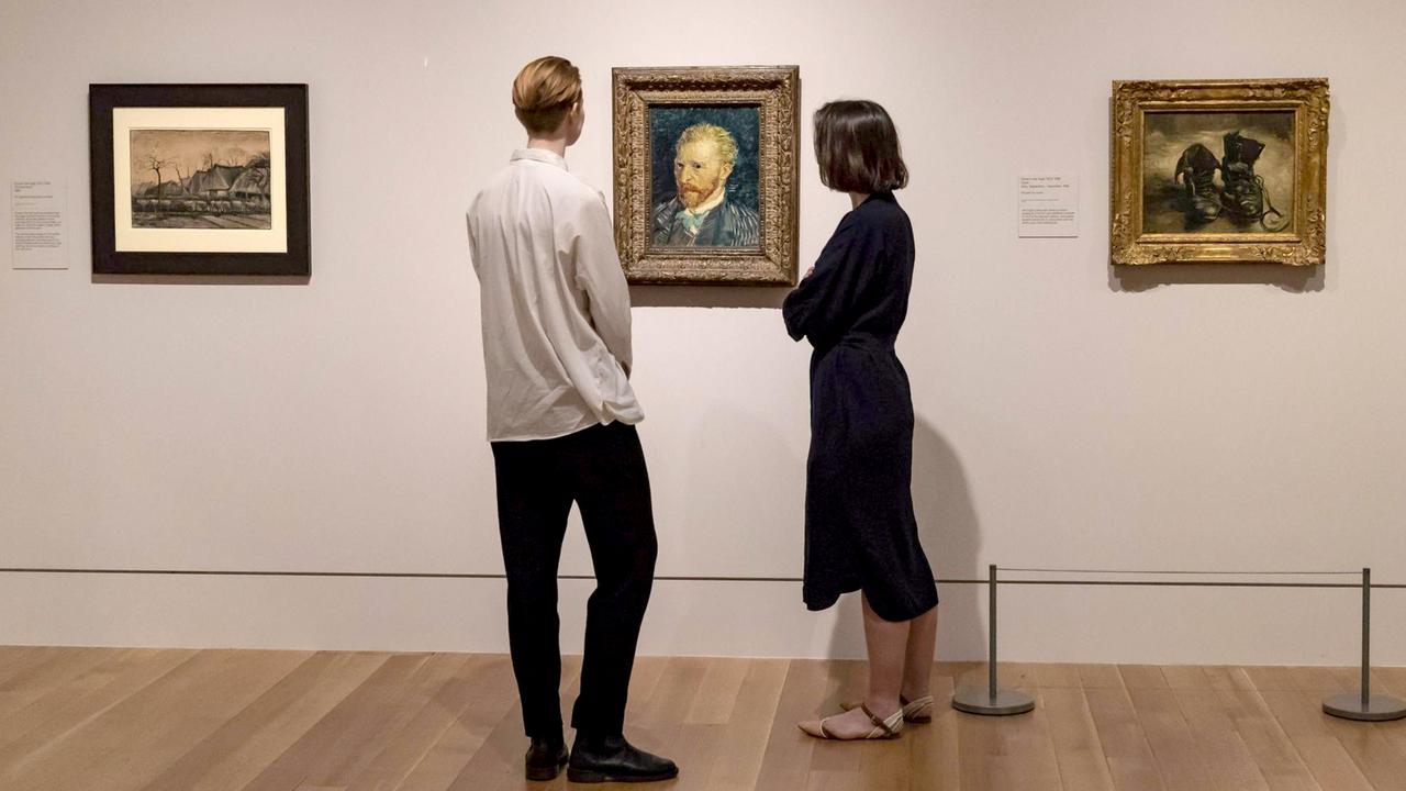 Ein Mann und eine Frau schauen sich ein Selbstportrait von Van Gogh in der Britain Tate an.