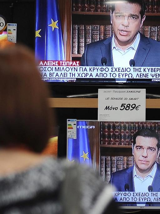 Eine Frau sieht in Athen die Fernsehansprache des griechischen Ministerpräsidenten Alexis Tsipras.