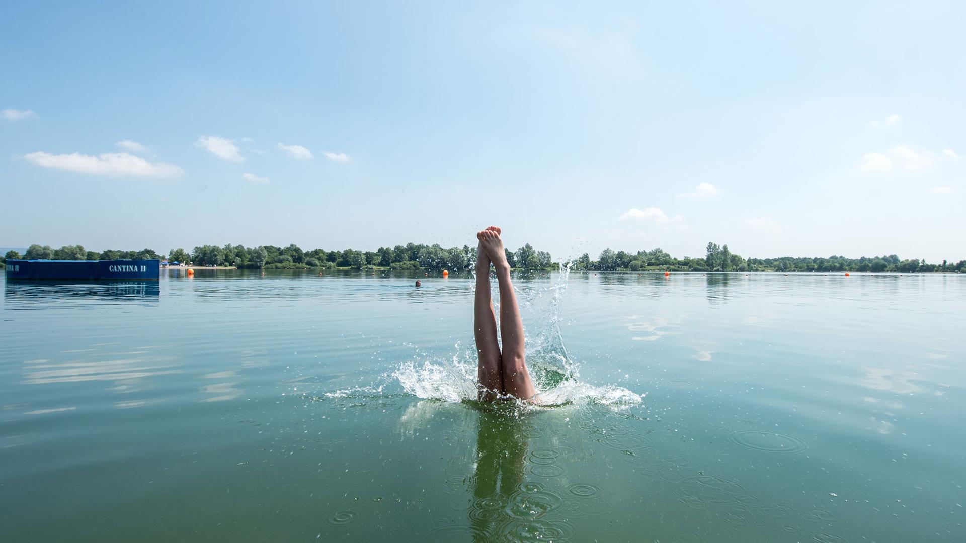 Eine Frau springt in den Guggenberger See nahe Neutraubling.