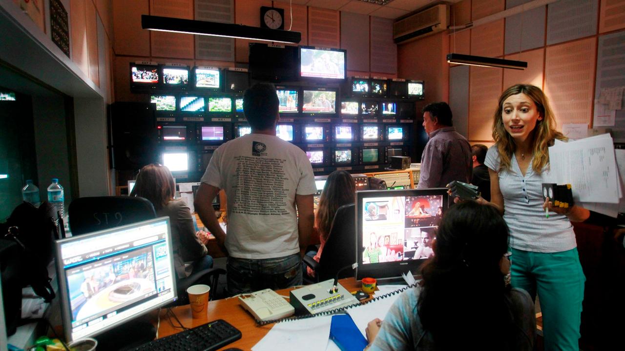 epa03742867 Greek state television ERT employees work in the control room inside the broadcasting station at ERT headquarters during a 24-hour general strike in Athens, Greece, 13 June 2013. Greek public transport and state services face disruption as lab