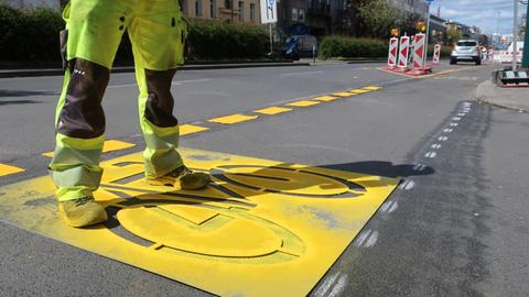Ein neuer Fahrradweg am Kottbusser Damm in Berlin-Kreuzberg: Auf einem gelben Piktogramm ist ein Fahrrad abgebildet.
