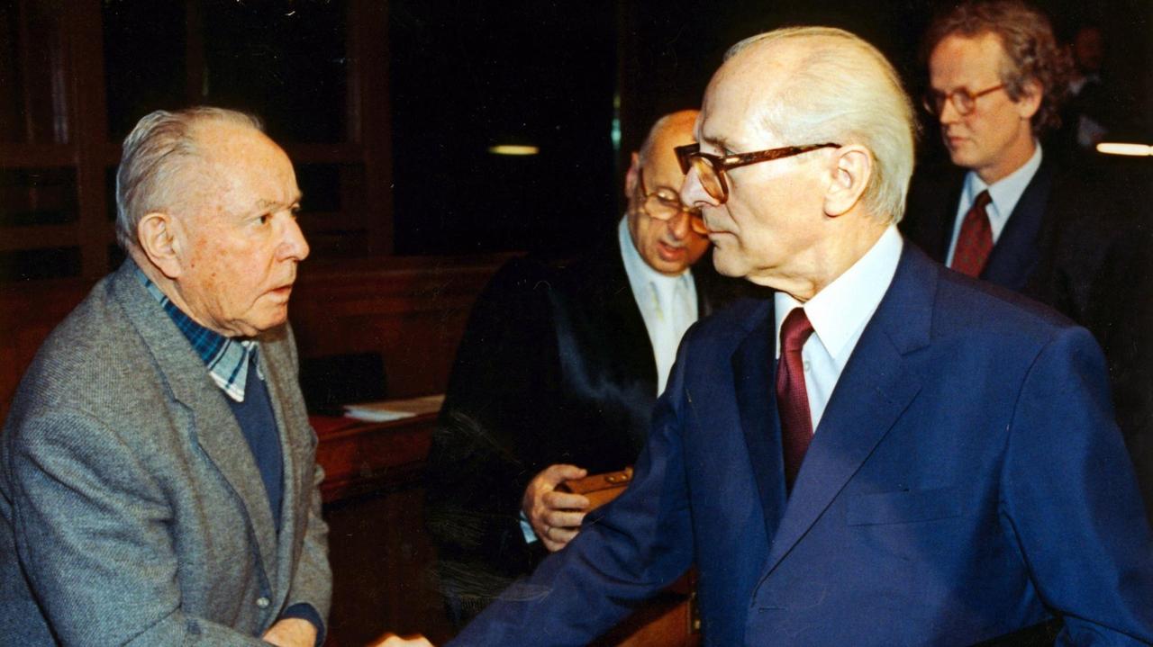 Der ehemalige DDR-Staatschef Erich Honecker (r) und der frühere Stasi-Chef Erich Mielke (l) verabschieden sich nach dem zweiten Prozess-Tag mit einem Händedruck. Der Honecker-Prozess wurde am 16. November 1992 im Kriminalgericht Moabit unter strengsten Sicherheitsvorkehrungen fortgesetzt. Honecker und Mielke müssen sich mit weiteren Mitangeklagten wegen der Todesschüsse an der innerdeutschen Grenze verantworten.